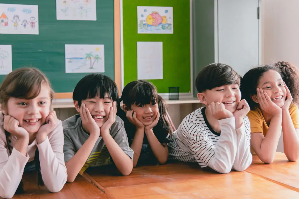 Group of primary kids eagerly listening to their English tutor
