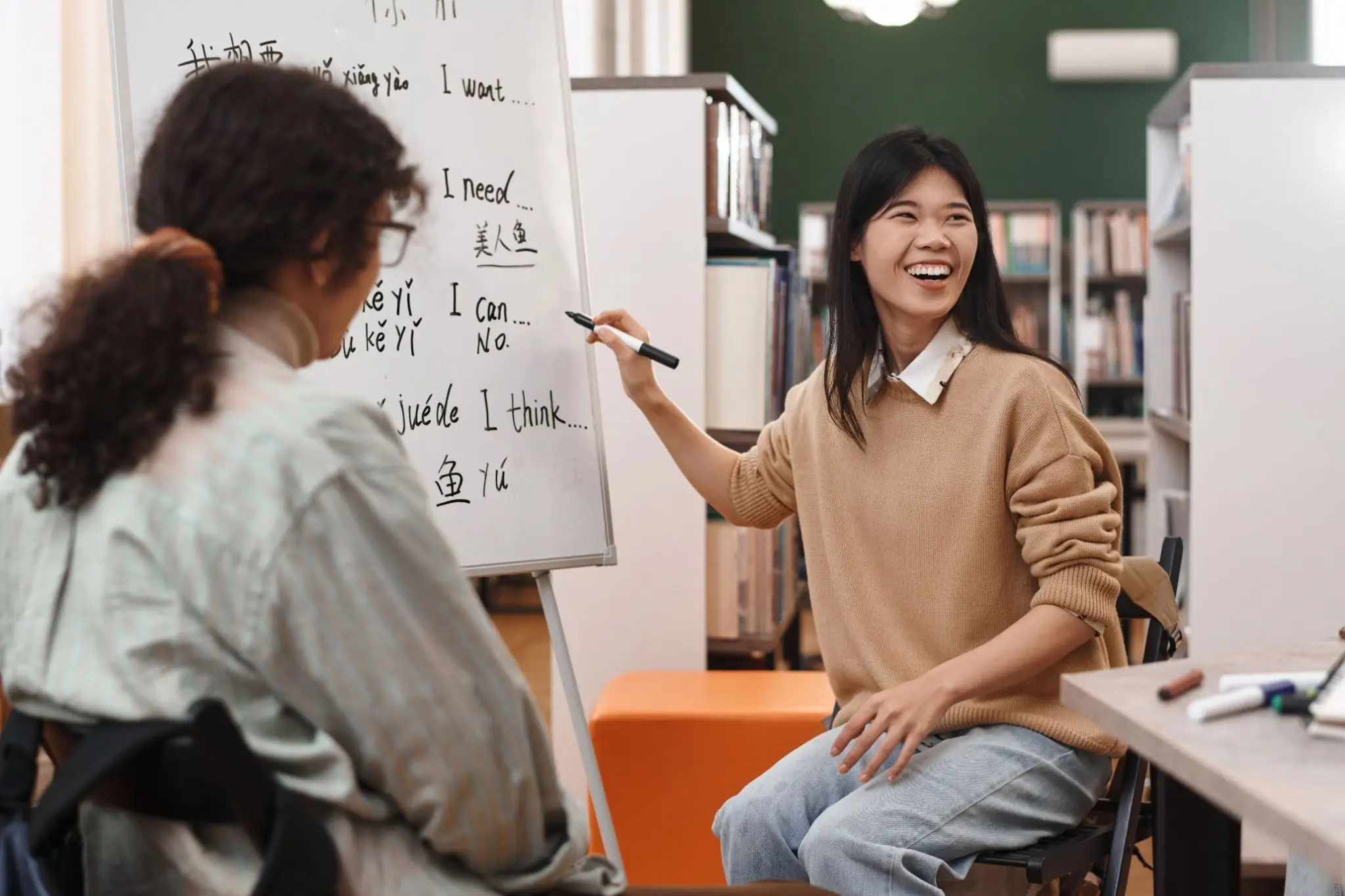 teacher writing english sentences on a whiteboard