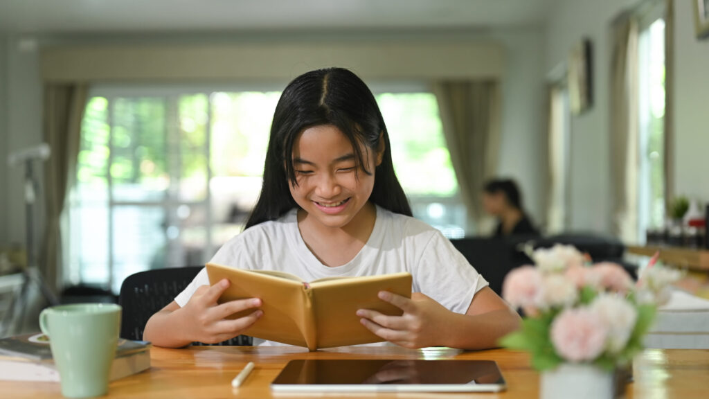Secondary 3 student reading a book at a study desk, representing the critical reading, analytical thinking, and independent learning skills needed before O-Level English.